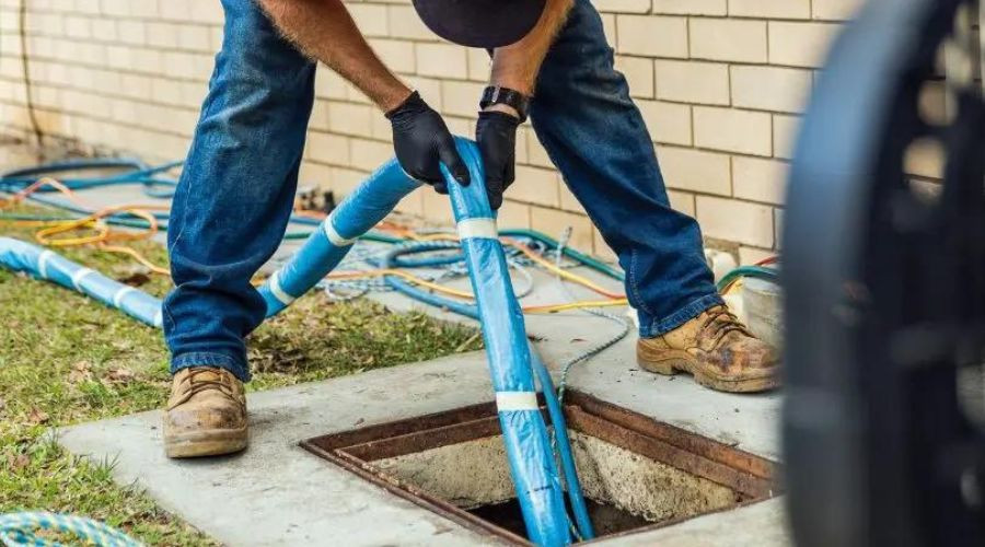 Technician using blue plumbing equipment to inspect a drainage system, emphasizing reliable plumbing services and diagnostics by Affordable Plumbing Solutions.